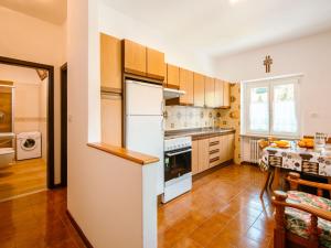 een keuken met houten kasten en een witte koelkast bij Apartment Pederiva - SOF740 by Interhome in Soraga