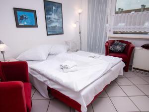 ein Hotelzimmer mit einem Bett und zwei Stühlen in der Unterkunft Apartment Am Deich by Interhome in Norddeich