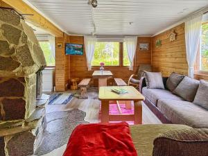 un soggiorno con divano e camino in pietra di Holiday Home Haapala by Interhome a Karjalaisenniemi