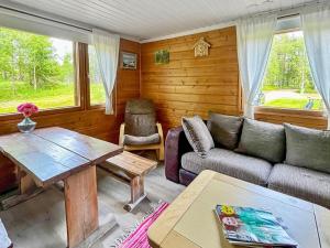 een woonkamer met een bank en een tafel bij Holiday Home Haapala by Interhome in Karjalaisenniemi