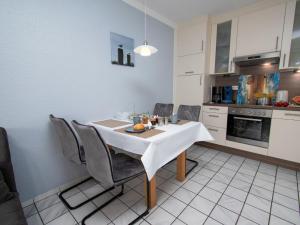 eine Küche mit einem weißen Tisch und Stühlen in einem Zimmer in der Unterkunft Apartment Krabbe by Interhome in Norddeich