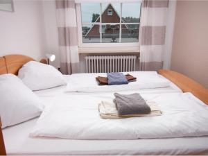 duas camas brancas com toalhas por cima em Apartment Krabbe by Interhome em Norddeich