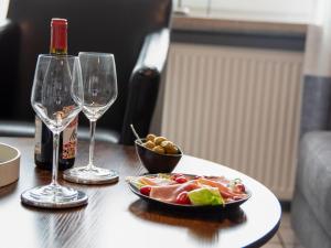 einen Tisch mit einem Teller Essen und zwei Weingläsern in der Unterkunft Apartment Krabbe by Interhome in Norddeich