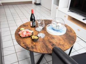 a table with a bottle of wine and glasses on it at Apartment Krabbe by Interhome in Norddeich +37 photos