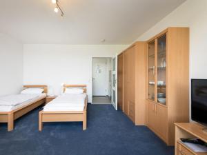 ラーンシュタインにあるApartment B712 by Interhomeのベッド2台、薄型テレビが備わる客室です。