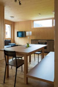 une salle à manger avec une grande table et des chaises en bois dans l'établissement Bergreich Appartement 3, à Schoppernau