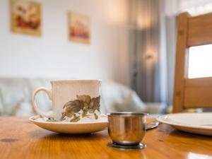 a coffee cup sitting on a wooden table next to a cup at Apartment A907 by Interhome in Lahnstein