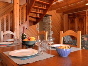 Holiday Home Houat-Hoedic-Belle-Ile - PHM301 by Interhome في Plouhinec: طاولة خشبية مع وعاء من الفواكه وزجاجة من النبيذ