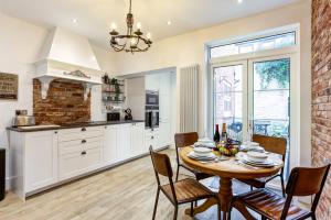 a kitchen and dining room with a table and chairs at Woodside Cottage, Congleton, Nr Peak District in Congleton