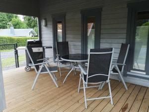 een patio met stoelen, een tafel en een grill bij Holiday Home Ferienhaus Barbara by Interhome in Enspel