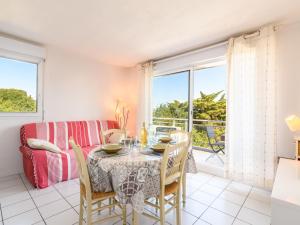a dining room with a table and chairs and a couch at Apartment Zéphyr-1 by Interhome in Arcachon