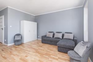 uma sala de estar com um sofá e duas cadeiras em Sunny Apartments with Parking & Balcony Łużycka by Renters em Świnoujście