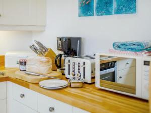 a kitchen counter with a toaster and a microwave at Holiday Home Haslam by Interhome in Saint Merryn