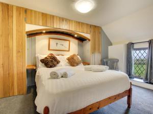 セント・デイビッズにあるHoliday Home Trefin by Interhomeの木製の壁のベッドルーム1室(白い大型ベッド1台付)
