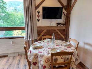 uma sala de jantar com uma mesa e uma televisão em Studio Castel des Roches-2 by Interhome em Saint-Gervais-les-Bains