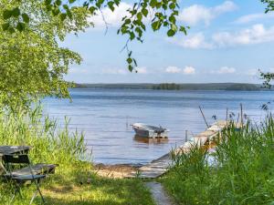 a boat sitting on the water next to a dock at Chalet Bengtstorp by Interhome in Gyttorp