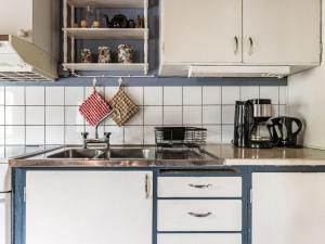 a kitchen with white cabinets and a sink at Holiday Home Forneboda by Interhome in Kyrkhult +14 photos