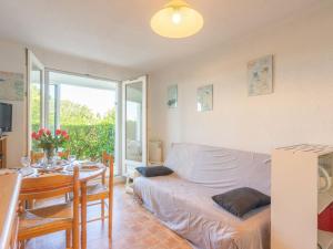 ein Wohnzimmer mit einem Bett und einem Tisch in der Unterkunft Apartment Les Jardins de l'Océan-40 by Interhome in Strand Pontaillac