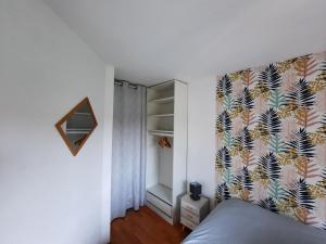 a bedroom with a bed with a floral wallpaper at Coeur Marina climatisé terrasse parking in Fréjus