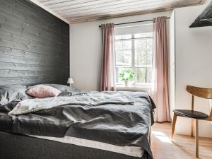 a bedroom with a black accent wall and a bed at Chalet Kringelfjorden Nävern by Interhome in Särna