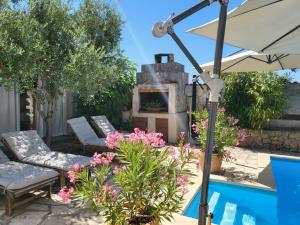 a patio with a stone fireplace next to a pool at Apartments Grgic in Njivice