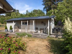 a small white cottage with a porch and patio at Chalet Ringsegård Höjden - HAL045 by Interhome in Falkenberg