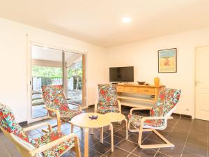 a living room with chairs and a table and a television at Holiday Home La Lette II Albizzias by Interhome in Saint-Julien-en-Born