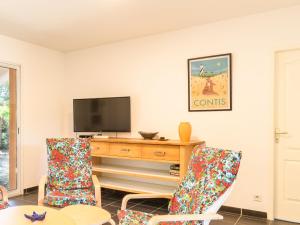 a living room with a tv and two chairs at Holiday Home La Lette II Albizzias by Interhome in Saint-Julien-en-Born +10 photos