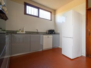 a kitchen with a white refrigerator and a window at Holiday Home De Carreço - CRR100 by Interhome in Carreço