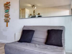 a couch in a living room with a mirror at Apartment Primavéra-8 by Interhome in Lacanau-Océan