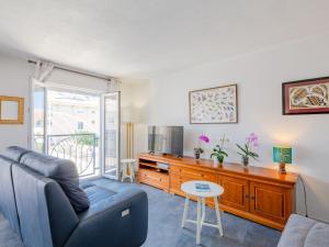 uma sala de estar com um sofá e uma televisão em Apartment Royal Marine-4 by Interhome em Fréjus
