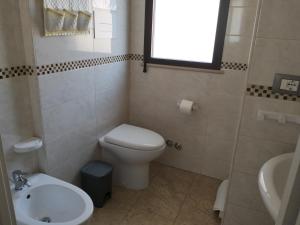 a small bathroom with a toilet and a sink at La Trinacria di Capo Passero in Portopalo