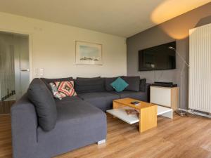 a living room with a gray couch and a table at Holiday Home Schwarzwald by Interhome in Dittishausen