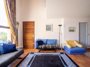 a living room with blue couches and a table at Holiday Home Le Belvédère by Interhome in La Londe-les-Maures