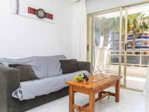 uma sala de estar com um sofá e uma mesa com copos de vinho em Apartment Jardines Family-4 by Interhome em Salou