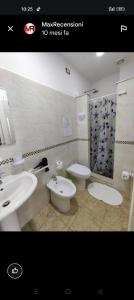 a bathroom with two sinks and a toilet and a shower at La Trinacria di Capo Passero in Portopalo