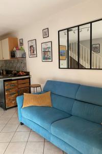 Un sofá azul en una sala de estar con cocina. en Holiday Home Le Puit Michel by Interhome, en Le Lavandou 33 fotos más
