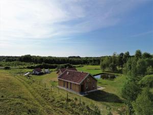 an aerial view of a wooden house in a field at Holiday Home Zagroda nad Krutynią by Interhome in Spychowo