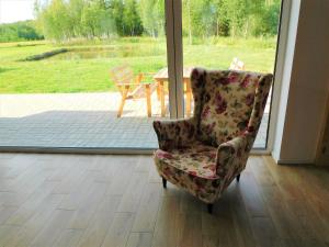 een stoel in een kamer met uitzicht op een patio bij Holiday Home Zagroda nad Krutynią by Interhome in Spychowo