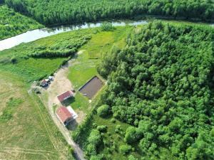 an aerial view of a field with trees and a river at Holiday Home Zagroda nad Krutynią by Interhome in Spychowo