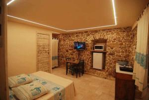 アルゲーロにあるSuite Principe Umberto Alghero Centralissimaのベッド2台、テーブル、キッチンが備わる客室です。