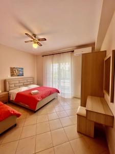 a bedroom with a bed and a ceiling fan at J&B Rooms Dhermi in Dhërmi