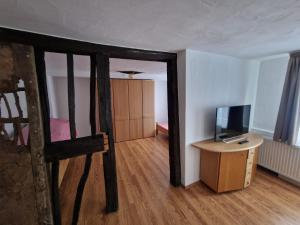 Zimmer mit einem Bett, einem TV und einem Schreibtisch in der Unterkunft Gasthof zum Stern in Bad Brückenau
