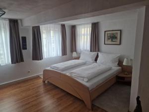 Schlafzimmer mit einem Bett mit weißer Bettwäsche und Fenstern in der Unterkunft Gasthof zum Stern in Bad Brückenau