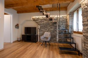 a living room with a stone staircase and a chair at Bed & Bike La Stalla in Masera