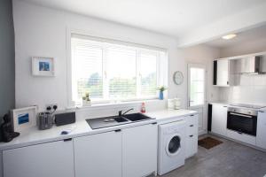 a white kitchen with a sink and a dishwasher at Beautifully Designed Pollok House in Glasgow