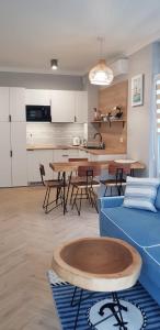 ein Wohnzimmer mit einem blauen Sofa und einem Tisch in der Unterkunft Uroczy Apartament Happy 28 tuż przy plaży. in Sianożęty