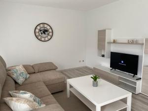 a living room with a couch and a tv at A Xaneiriña in Camariñas