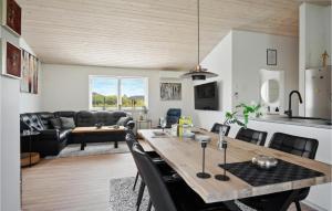 a dining room and living room with a table and chairs at Cozy Home In Sams With Kitchen in Onsbjerg