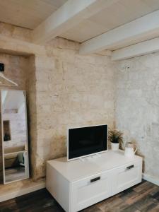 un televisor en una cómoda blanca en una habitación en Casa De Amicis 24, en Sammichele di Bari